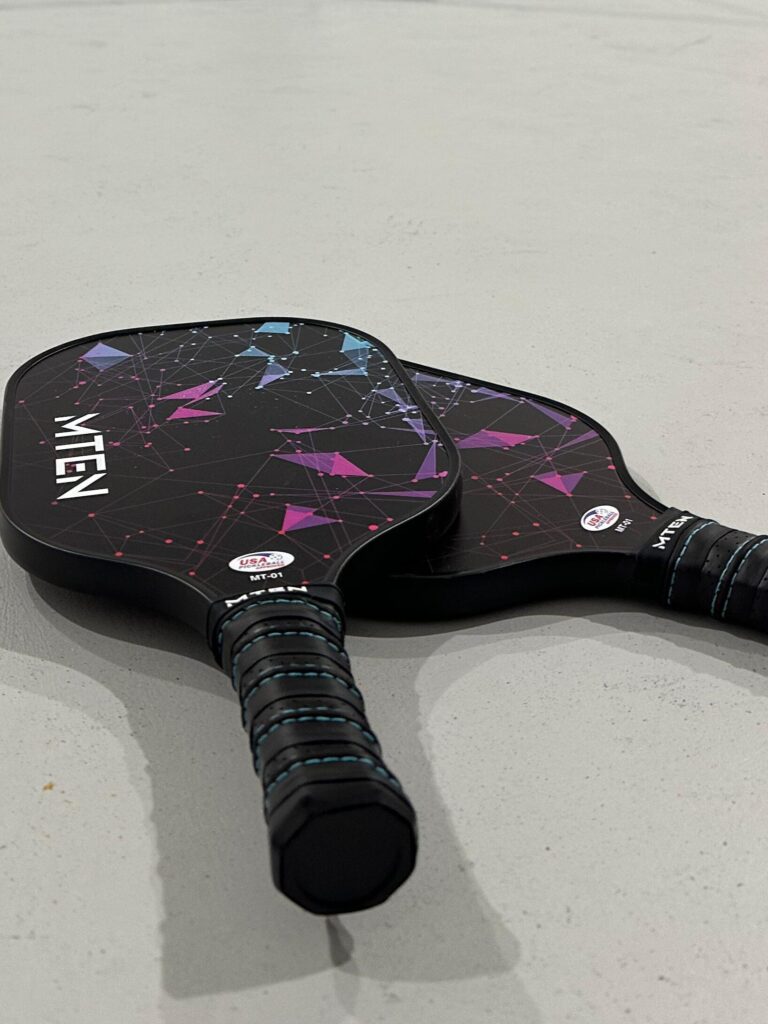 2 black MTen pickleball paddles highlighting the compact nature of pickleball paddles  to fit in your carry on luggage.