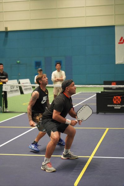 Kondor China pickleball player John Urdigan standing att the non volley zone with a paddle in his hand.